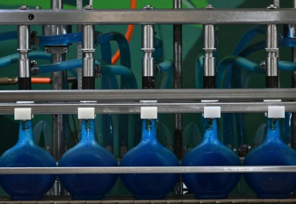 Des bouteilles de liqueur curaçao sur une ligne de production de la distillerie Willemstad, sur l'île néerlandaise de Curaçao, au large du Venezuela, le 9 avril 2026