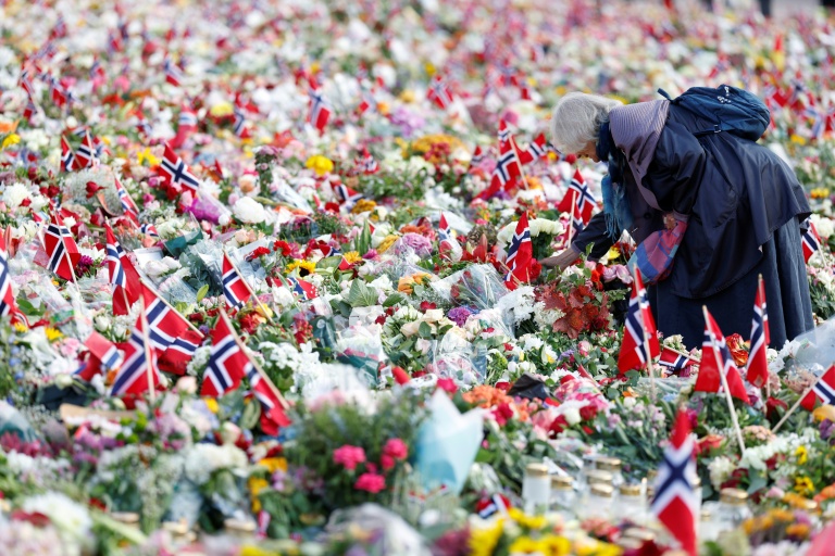 Une femme se tient au milieu d’un mémorial improvisé en hommage au roi Harald V de Norvège, décédé, sur la place du Palais royal à Oslo, le 31 août 2026
