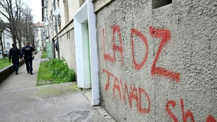 Des policiers patrouillent à proximité d'un mur avec un tag DZ désignant la DZ mafia à Avignon le 13 mars 2025