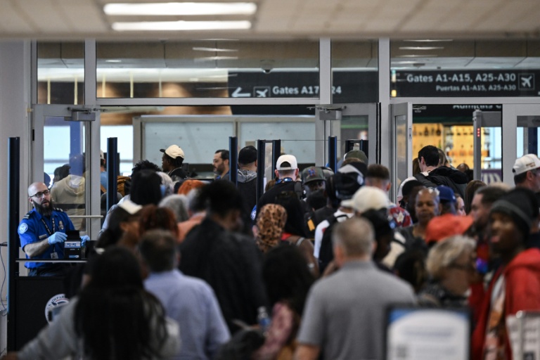 Des voyageurs patientent dans de longues files d'attente aux contrôles de sécurité de l'aéroport intercontinental George Bush de Houston, au Texas, le 23 mars 2026