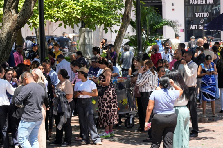 Des personnes évacuées d'un immeuble rassemblées sur une place après qu'un violent séisme a frappé le Panama, le 9 octobre 2026 à Panama City 