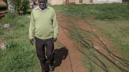 Un habitant du township de Katlehong, près de Johannesburg, marche à côté des câbles qui raccordent illégalement son quartier au réseau électrique, le 5 octobre 2026