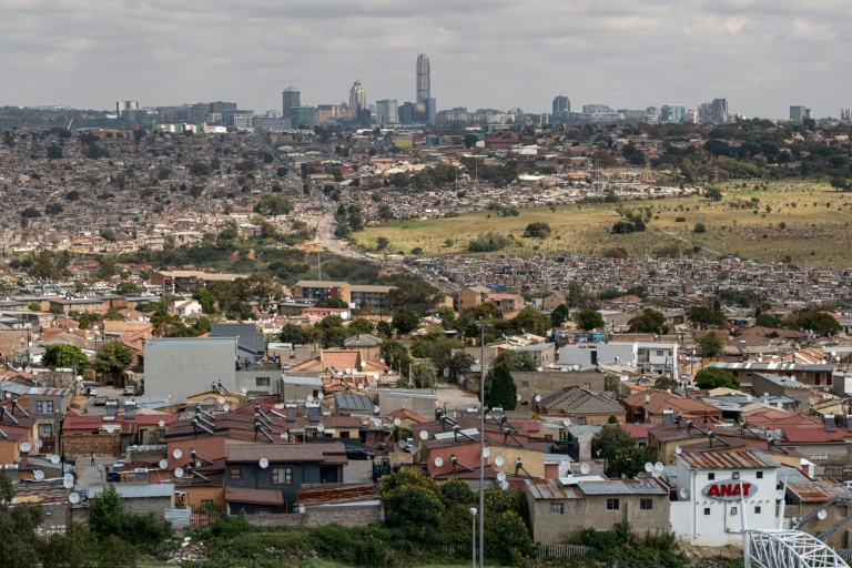 Vue générale du township d'Alexandra, avec à l'arrière-plan les immeubles de bureau du quartier de Sandton, à Johannesburg, le 4 mai 2025