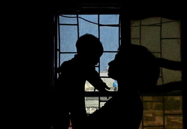Une Soudanaise, survivante d'un viol tient son bébé dans ses bras, dans un appartement à Khartoum, le 25 avril 2026 au Soudan