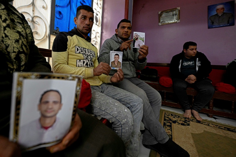 Des proches tiennent des portraits (de gauche à droite) d'Ahmed Kamel, 29 ans, Adel Hamed, 37 ans et Mohamed Abdelsamad, 32 ans, portés disparus en Méditerranée alors qu’ils tentaient de rejoindre l’Europe via la Libye, lors d’un entretien dans le village égyptien d’Abdallah Aziza, le 21 janvier 2026