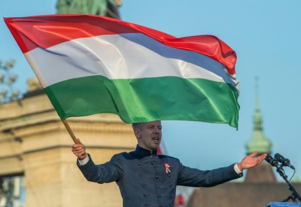 Le chef de l'opposition et président du parti Tisza, Peter Magyar, tient un drapeau hongrois lors d'un rassemblement électoral à Budapest, le 15 mars 2026