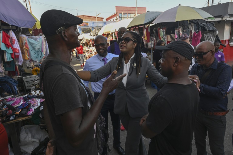 L'opposante Amanzia Walton-Desir (C), candidate outsider à la présidentielle au Guyana, s'adresse à des habitants sur marché de Georgetown, le 25 août 2025 