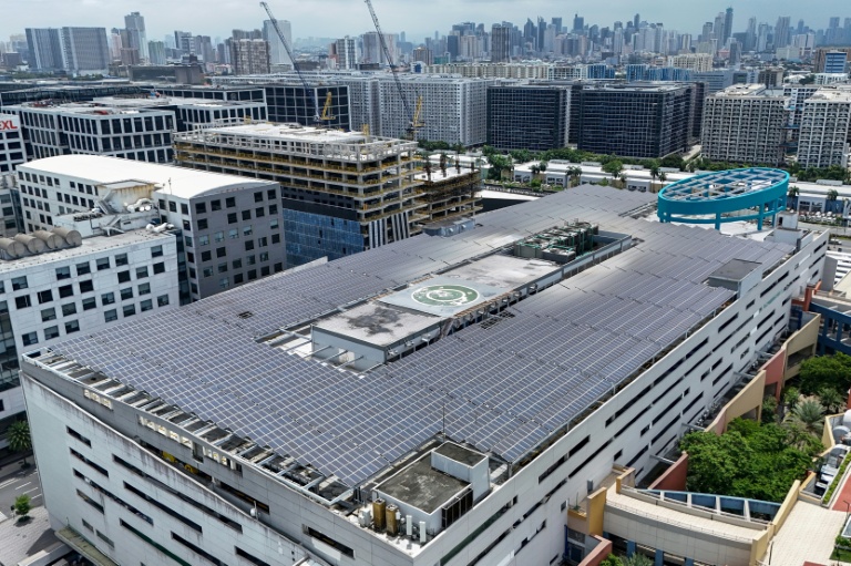 Vue aérienne montrant des panneaux solaires sur le toit d'un centre commercial SM à Manille, le 13 juillet 2026