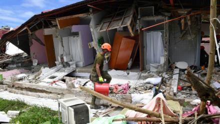 Un sauveteur arrive devant un  bâtiment effondré où la disparition de trois personnes a été signalée après un séisme, dans la ville de Bogo, aux Philippines, le 1er octobre 2025