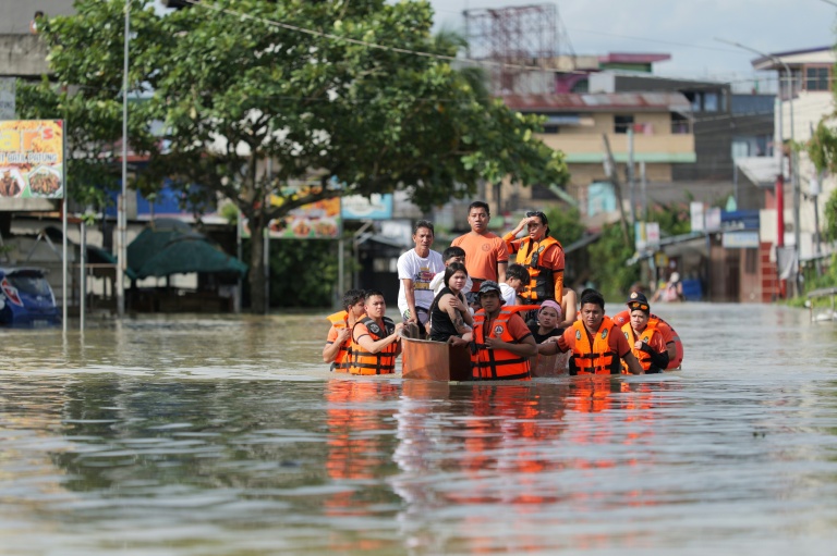 Des secouristes évacuent des habitants en bateau à Tuguegarao, au nord de Manille, alors que les eaux de crue continuent d'inonder les maisons en raison des fortes pluies provoquées par le super typhon Fung-wong, le 11 novembre 2025 aux Philippines