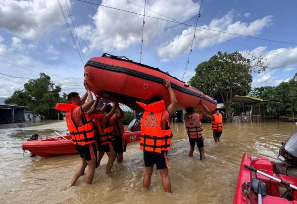 Des secouristes transportent des bateaux pneumatiques pour évacuer des habitants près de Tuguegarao, au nord de Manille, alors que les eaux de crue continuent d'inonder les maisons en raison des fortes pluies provoquées par le super typhon Fung-wong, le 11 novembre 2025 aux Philippines
