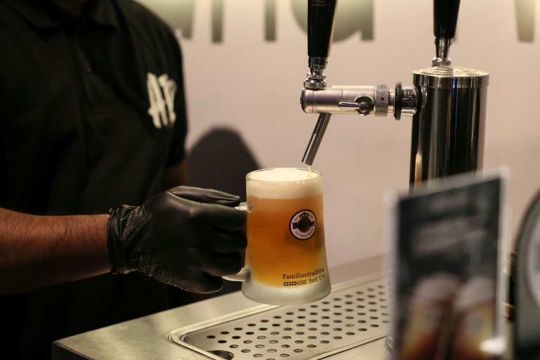 Un employé d'une brasserie de Ryad en Arabie saoudite sert une bière sans alcool, le 24 octobre 2025