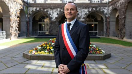Le maire de Clermont-Ferrand, Julien Bony, ceint de son écharpe tricole, devant la mairie, le 27 mars 2026 dans le Puy-de-Dôme