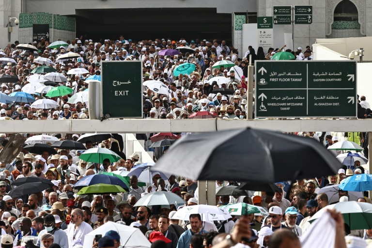Des fidèles musulmans déambulent dans le complexe de la Grande Mosquée sous les brumisateurs installés dans la ville sainte de La Mecque, le 24 mai 2026  en Arabie saoudite, à la veille du pèlerinage annuel du Hajj