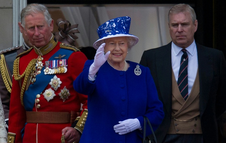 La reine Elizabeth II salue la foule depuis le balcon du palais de Buckingham, entourée de ses fils, Charles et Andrew