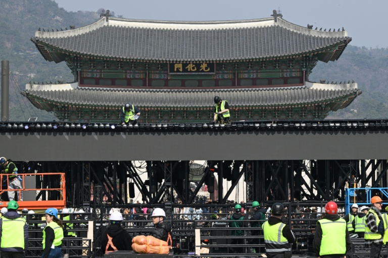 Des ouvriers installent la scène pour le concert de retour du groupe de K-pop BTS devant la porte Gwanghwamun (en haut), l'entrée principale du palais de Gyeongbokgung à Séoul, le 16 mars 2026 en Corée du Sud