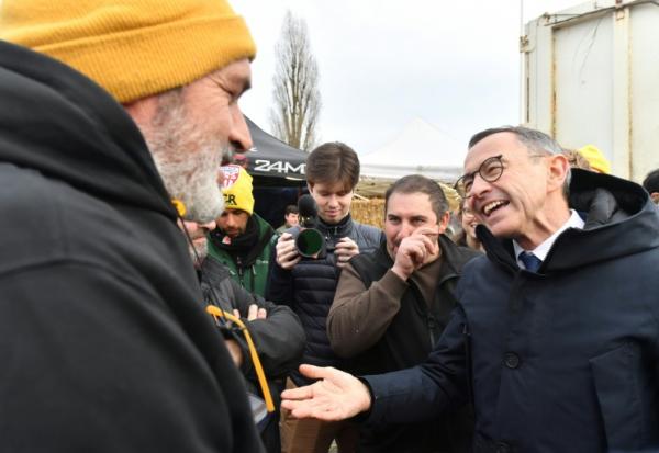 Le président des Républicains Bruno Retailleau (D) discute avec des agriculteurs de la Coordination rurale le 15 janvier 2026 à Saint-Pierre-des-Corps, près de Tours