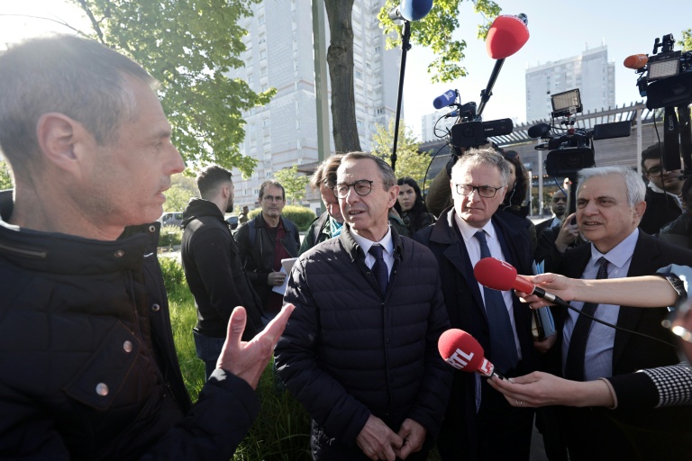 Le candidat LR à la présidentielle Bruno Retailleau (c) parle avec un habitant du quartier Pablo Picasso, accompagné par le député Philippe Juvin (2e d) et le premier vice-président du Sénat Roger Karoutchi (d), le 23 avril 2026 à Nanterre