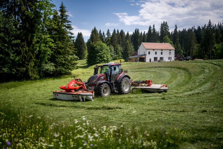Yannik Melly, un agriculteur installé au pied du massif du Jura et propriétaire d’un champ à cheval sur la France et la Suisse, fauche à Prémanon, le 23 juin 2026