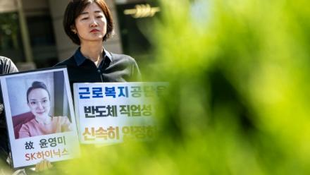 Militants et proches brandissent le portrait d'une ancienne employée de SK hynix, lors d'un rassemblement devant une antenne du Service sud-coréen d'indemnisation et de protection sociale des travailleurs, à Séoul, le 7 octobre 2026