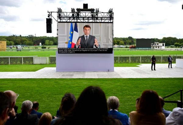 Le président de la République Emmanuel Macron prononce un discours sur écran géant lors d'un événement organisé par le Medef  à Paris le 28 août 2023