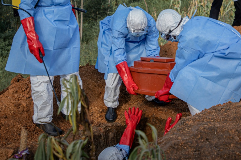 Des bénévoles déposent le cercueil d’un enfant de 3 ans, présumé mort de la maladie à virus Ebola, lors de ses funérailles dans un cimetière de Bunia, dans l'est de la RDCongo, le 11 juin 2026.
