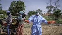 Dieudonné Sezabo, un agent de santé, demande de l'aide pour accueillir une jeune femme soupçonnée d'avoir la maladie Ebola, à l'hôpital de Rwampara, dans le nord-est de la République démocratique du Congo (RDC) le 26 mai 2026

