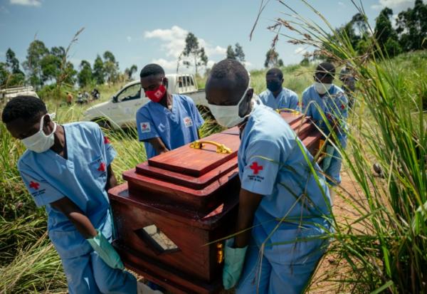 Des membres d'une équipe de la Croix-Rouge congolaise transportent le cercueil d'une femme qui serait décédée des suites de la maladie à virus Ebola lors de son enterrement dans les règles de sécurité dans un cimetière de Bunia, en RDC, le 7 juin 2026.