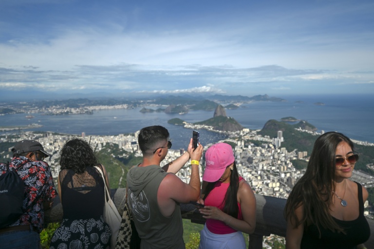 Un touriste prend des photos du Christ Rédempteur sur le mont Corcovado, dans le parc national de la forêt de Tijuca, à Rio de Janeiro, au Brésil, le 10 décembre 2025