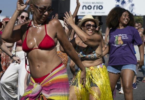 Des fans de la chanteuse colombienne Shakira apprennent la chorégraphie de sa chanson "Waka Waka (This Time for Africa)" sur la promenade de Copacabana, devant la scène où elle se produira à Rio de Janeiro, au Brésil, le 26 avril 2026