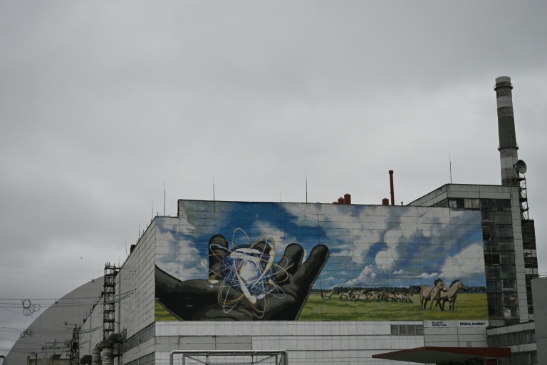 La centrale nucléaire de Tchernobyl et, en arrière plan, une partie du nouveau confinement de sécurité, un dôme métallique recouvrant le sarcophage du quatrième réacteur détruit lors de l'invasion russe de l'Ukraine, le 9 avril 2026 à Tchernobyl