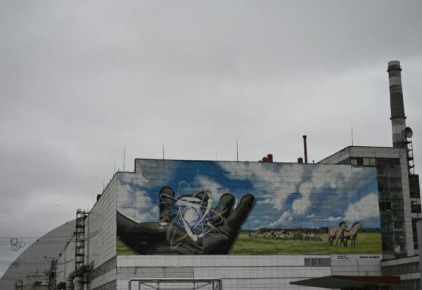 La centrale nucléaire de Tchernobyl et, en arrière plan, une partie du nouveau confinement de sécurité, un dôme métallique recouvrant le sarcophage du quatrième réacteur détruit lors de l'invasion russe de l'Ukraine, le 9 avril 2026 à Tchernobyl