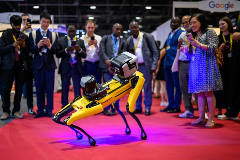 Des visiteurs photographient un robot de Boston Dynamics ressemblant à un chien, lors du Sommet mondial AI for Good