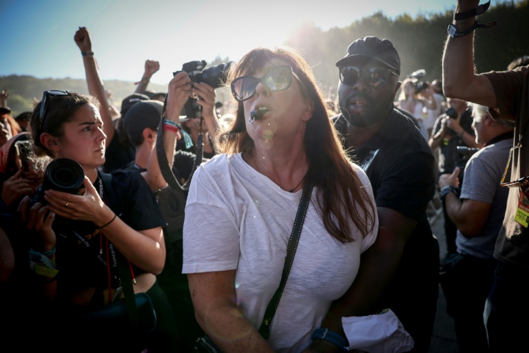 Une manifestante est expulsée par la sécurité après avoir tenté d'interrompre le concert de Kneecap, le 24 août 2025 à Saint-Cloud, près de Paris, lors du festival Rock en Seine