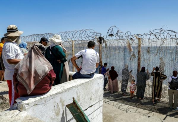 Des proches de migrants ayant traversé illégalement la frontière entre le Maroc et l'enclave espagnole de Ceuta attendent de leurs nouvelles, dans la ville marocaine de Fnideq le 2 août 2026