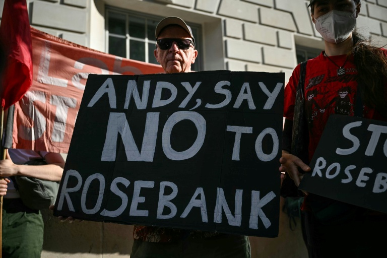 Un homme tient une pancarte contre le projet de champ pétrolier Rosebank, en mer du Nord; au large de l'Écosse, alors que des militants  écologistes manifestent à Londres, le 22 juillet 2026