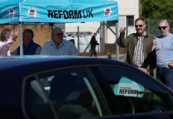 Des militants du parti Reform à Merthyr Tydfil, au Pays de Galles, le 24 avril 2026, pendant la campagne électorale 