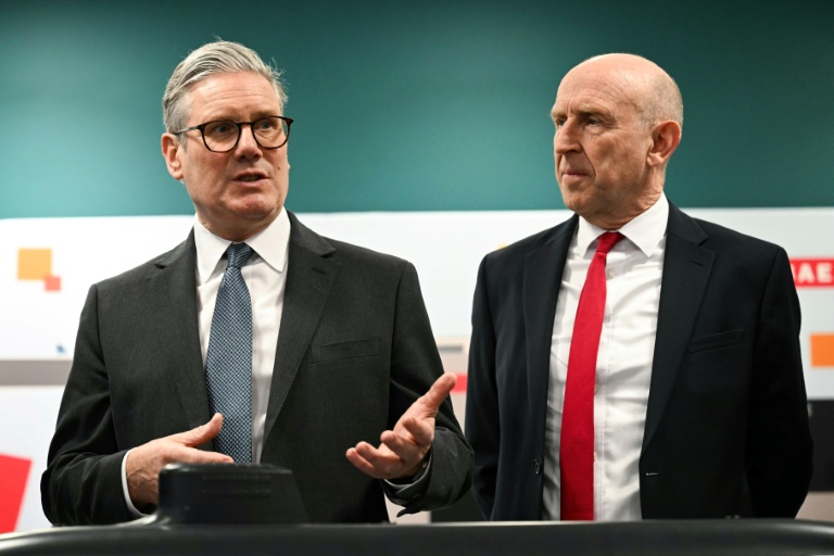 Le Premier ministre britannique Keir Starmer (g.) et le secrétaire à la Défense John Healey lors d'une rencontre avec des apprentis de l'entreprise aérospatiale BAE system, à Barrow-in-Furness, dans le nord-ouest de l'Angleterre, le 20 mars 2025