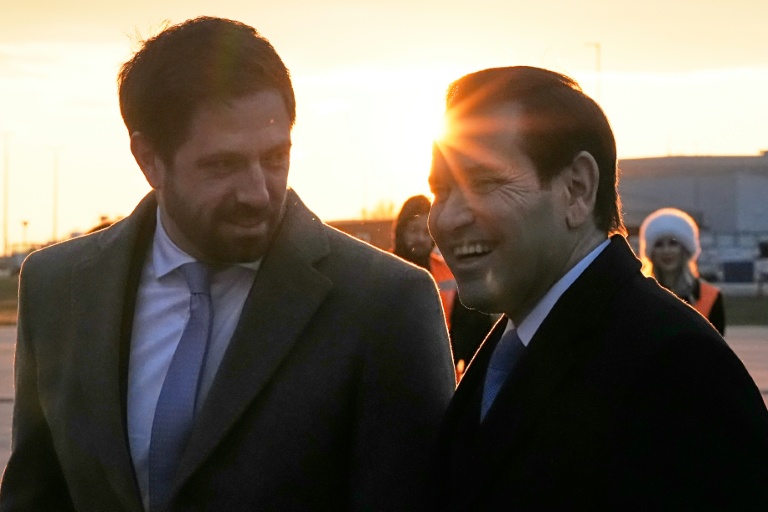 Le chef de la diplomatie américaine Marco Rubio (d) accueilli par le vice-ministre hongrois des Affaires étrangères, Levente Magya, à son arrivée à l'aéroport de Budapest, en Hongrie, le 15 février 2026