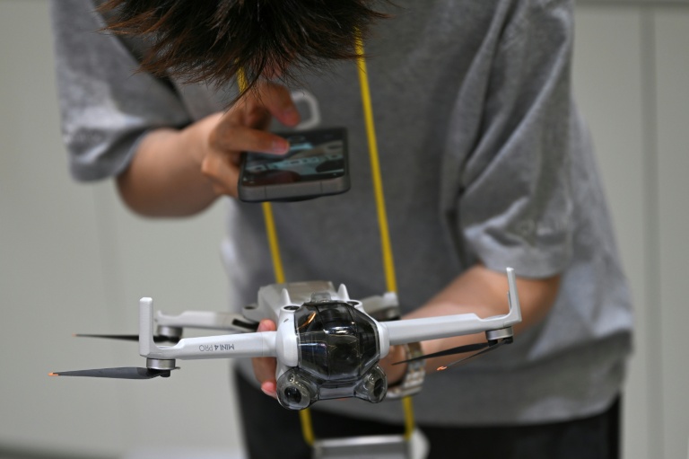Un employé d’un point de rachat de drones, installé dans un centre commercial de Pékin, inspecte un appareil apporté par son propriétaire, le 16 septembre 2026.