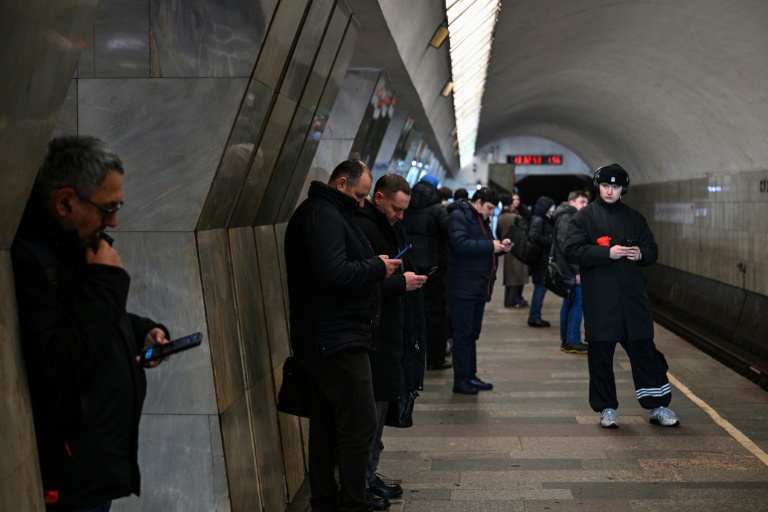 Des personnes utilisent leur smartphone, le 12 février 2026 dans le métro à Moscou