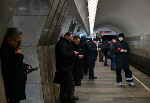 Des personnes utilisent leur smartphone, le 12 février 2026 dans le métro à Moscou