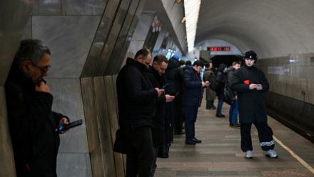 Des personnes utilisent leur smartphone, le 12 février 2026 dans le métro à Moscou