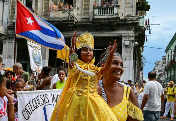Une fidèle brandit une poupée représentant la Vierge de la Charité, dans la religion catholique, et Oshun dans la religion yoruba, lors de la traditionnelle procession en leur honneur, à La Havane, le 8 septembre 2026