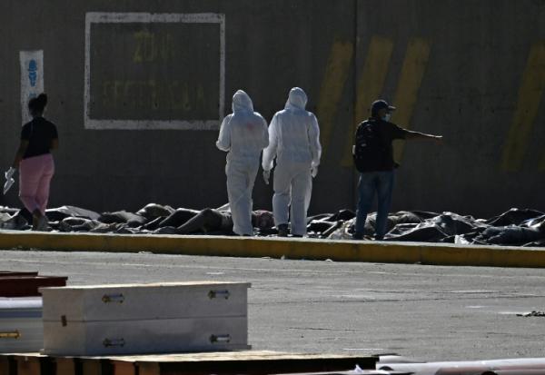 Des experts médicolégaux procèdent à l'identification de corps étendus au sol dans une morgue de fortune située dans le port de La Guaira, au Venezuela, le 29 juin 2026