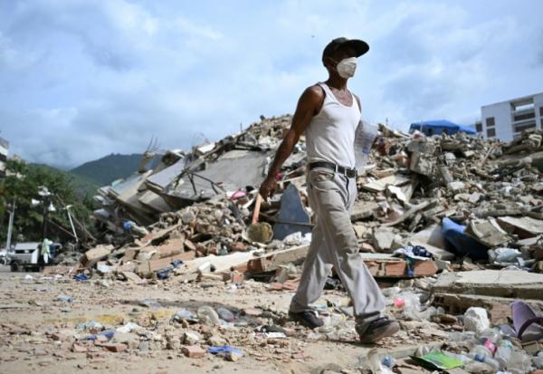 Un homme marche parmi les ruines d'immeubles effondrés à Caraballeda, dans l'Etat de La Guaira, au Venezuela, le 8 juillet 2026, à la suite du puissant double séisme