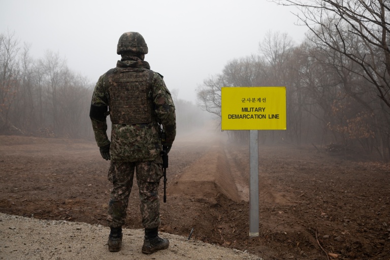 Un soldat sud-coréen devant un panneau marquant la ligne de démarcation militaire entre la Corée du Sud et la Corée du Nord, le 3 décembre 2018 près de Cheorwon, dans le nord de la Corée du Sud