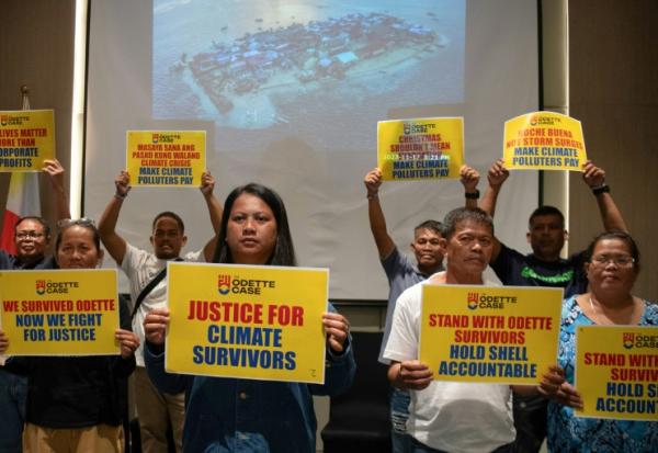 Trixy Elle (c, g) et d'autres survivants du typhon Rai rassemblés lors d'une conférence de presse à Manille, le 11 décembre 2025 aux Philippines