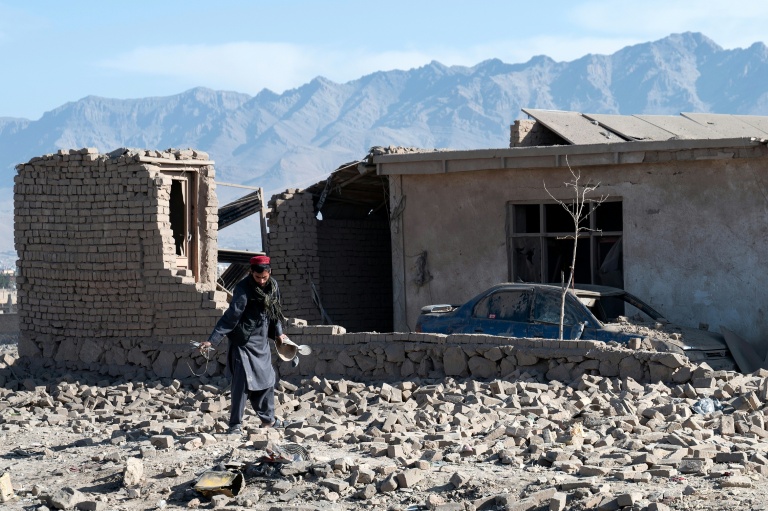 Un habitant devant une maison endommagée par  une frappe aérienne pakistanaise, en périphérie de Kaboul, le 13 mars 2026 en Afghanistan