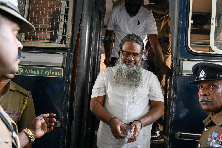 Des policiers escortent les accusés impliqués dans les attentats de Pâques 2019, lors du prononcé du verdict à la Haute Cour de Colombo, le 22 septembre 2026 au Sri Lanka